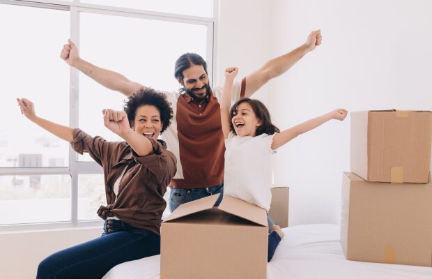 Smiling family carrying boxes into their Keighley home