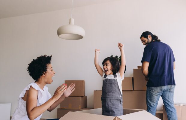Family with children carrying boxes into their new Huddersfield property