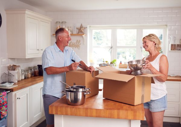 Couple unpacking boxes in a bright kitchen