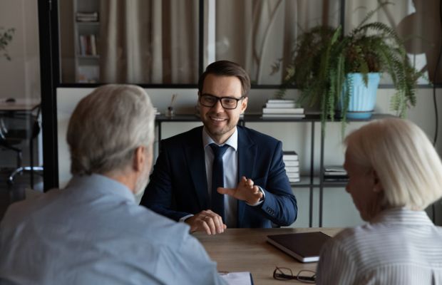 Three people in a meeting one smiling and gesturing