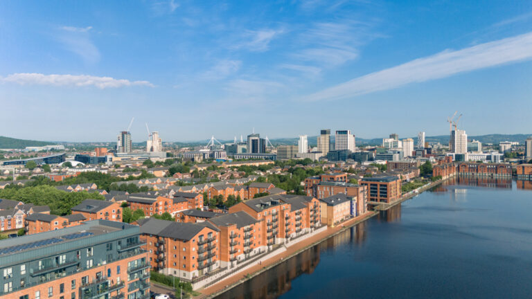Aerial view of Cardiff city skyline and waterfront apartments, showcasing key areas for property investment and rentals.