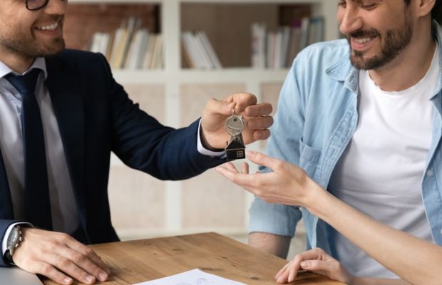 Key handover between two individuals at a table