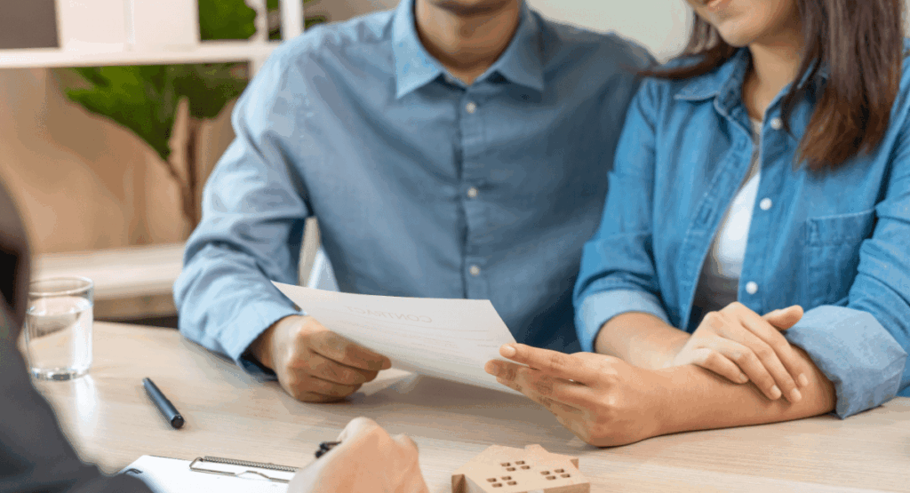Couple reviewing a rental contract at a desk, discussing energy-saving advice and tenant responsibilities for managing winter bills.