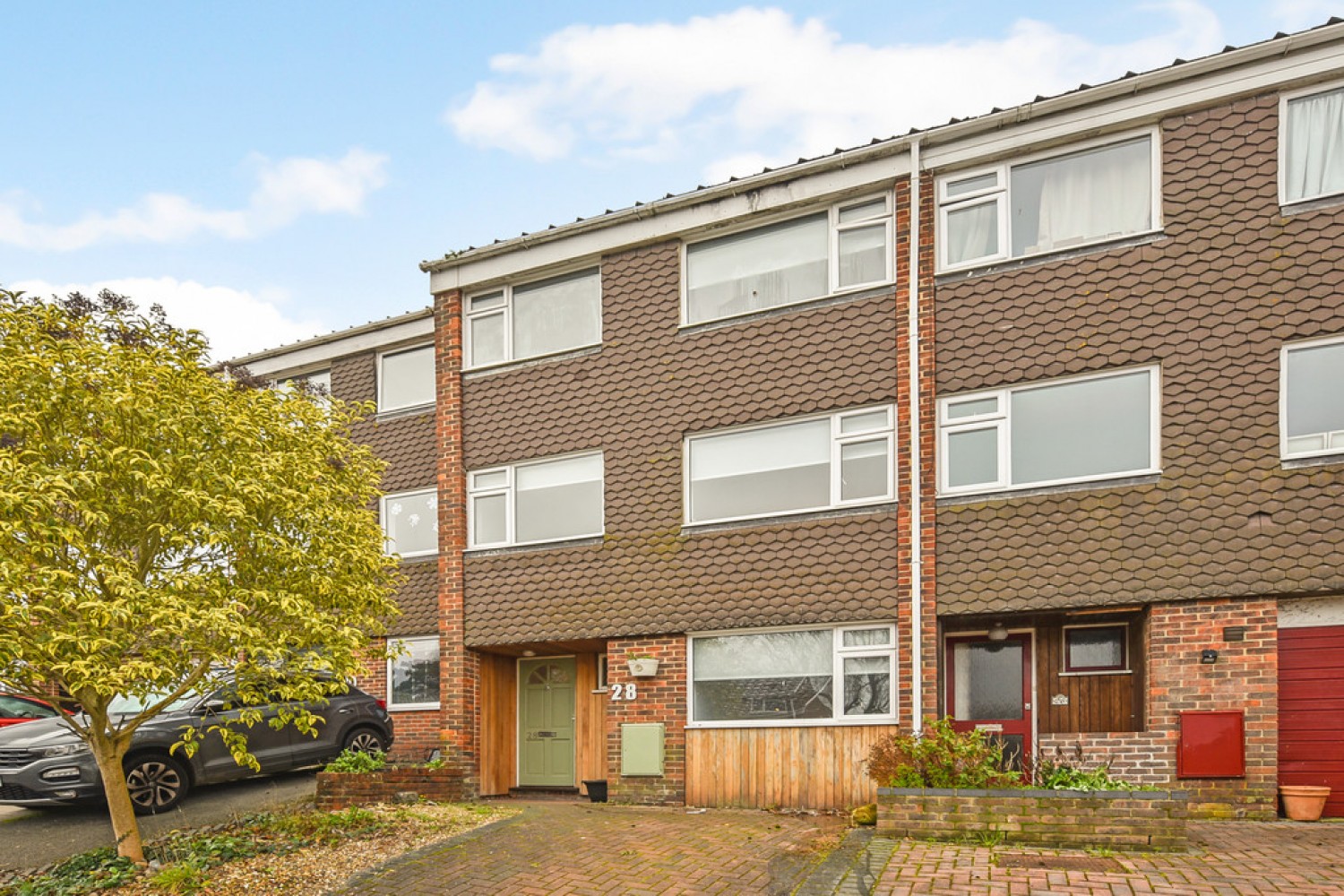 Modern brick semi-detached house with a pitched roof and wooden front door.