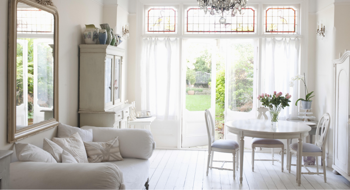 A beautifully presented bright white living and dining room with large windows opening onto a garden, illustrating the importance of kerb appeal and presentation when selling a home in Widnes.