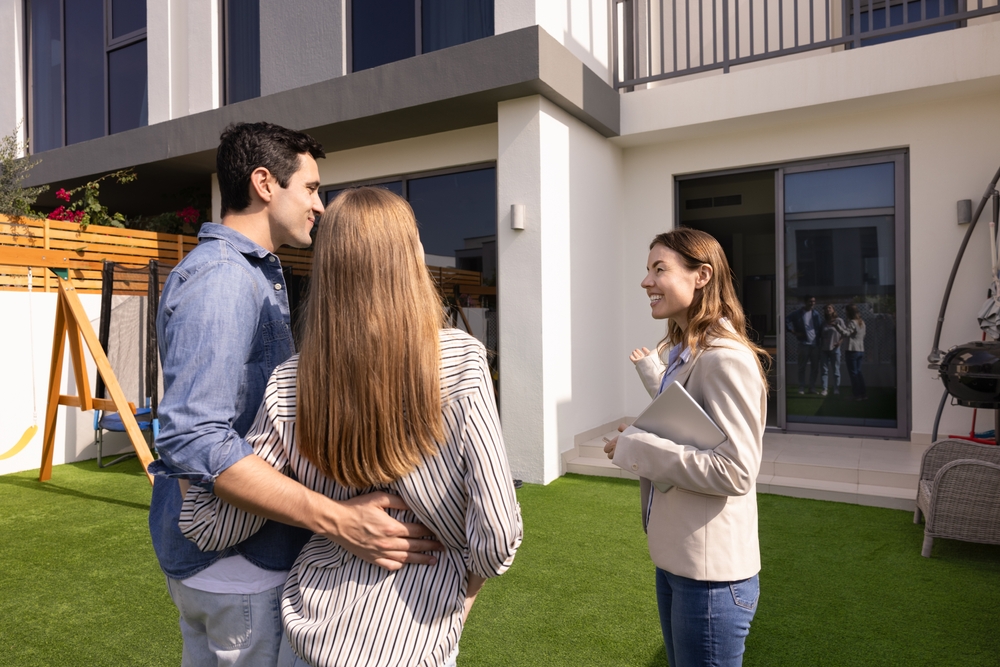 Couple talks to a woman outside a modern building.