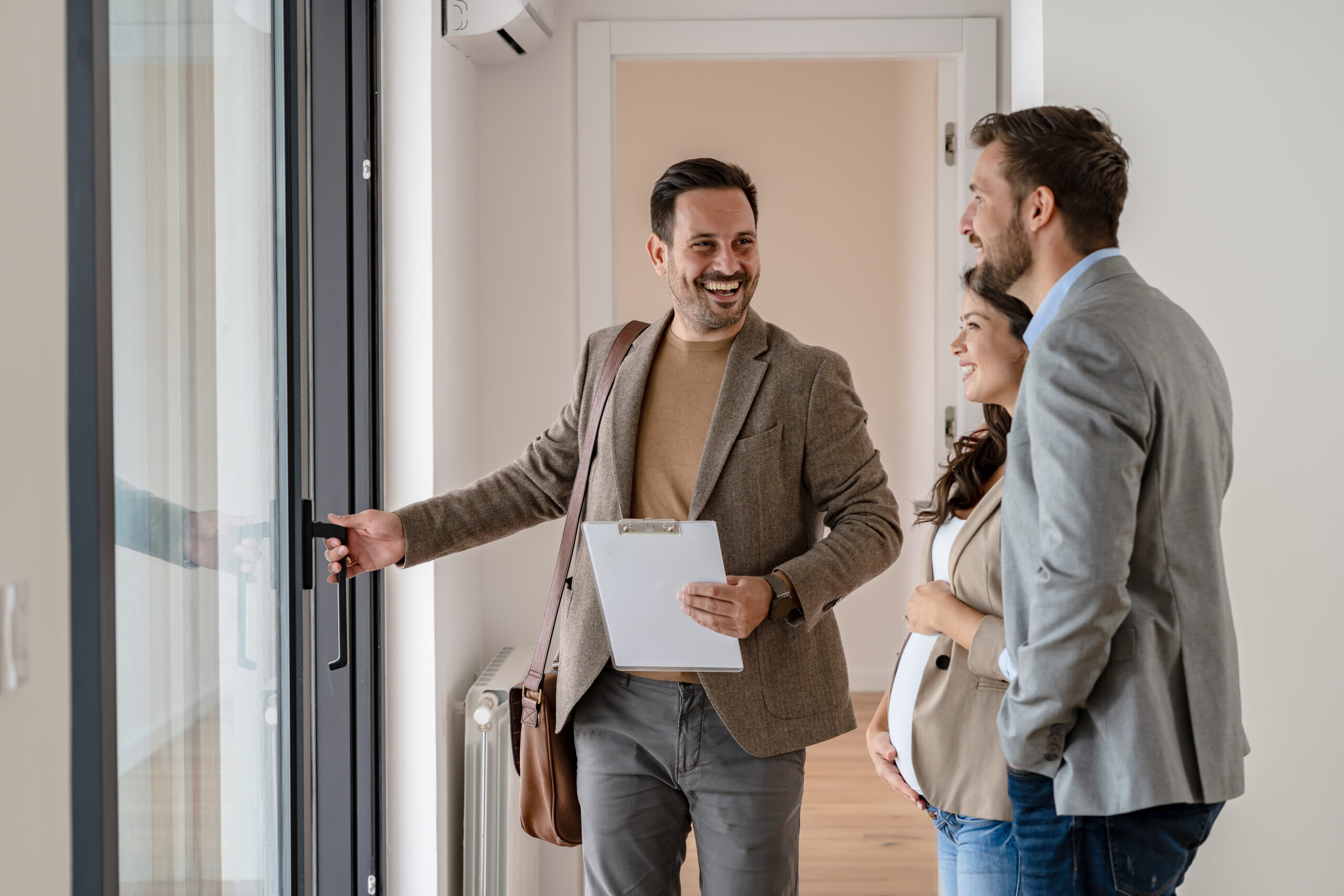 Smiling estate agent showing a couple around a modern home in Solihull, representing personal service and local expertise from Martin & Co
