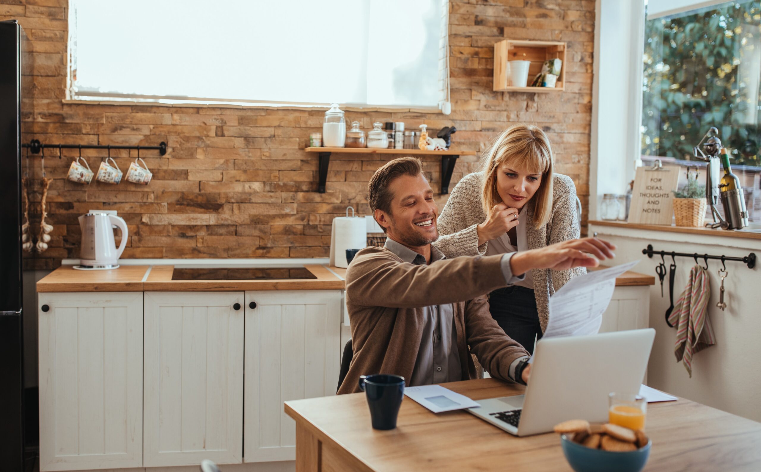 Estate agent and his client looking at a laptop and discussing