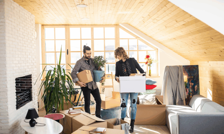 Couple unpacking boxes in a bright new home, representing buying a property in Solihull and South Birmingham