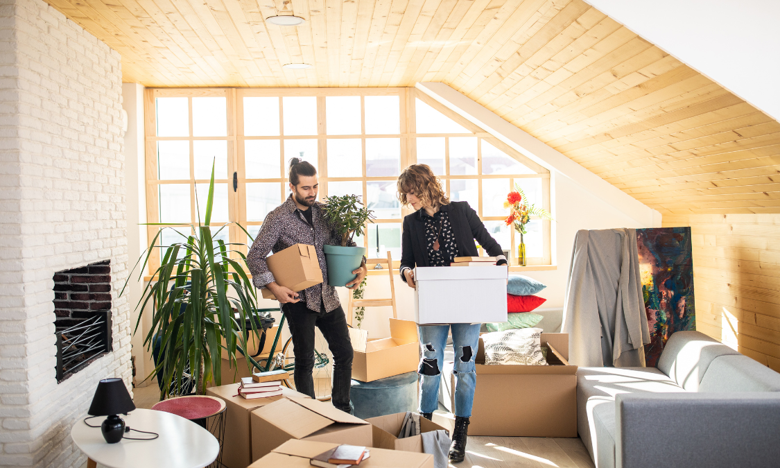 Couple unpacking boxes in a bright new home, representing buying a property in Solihull and South Birmingham