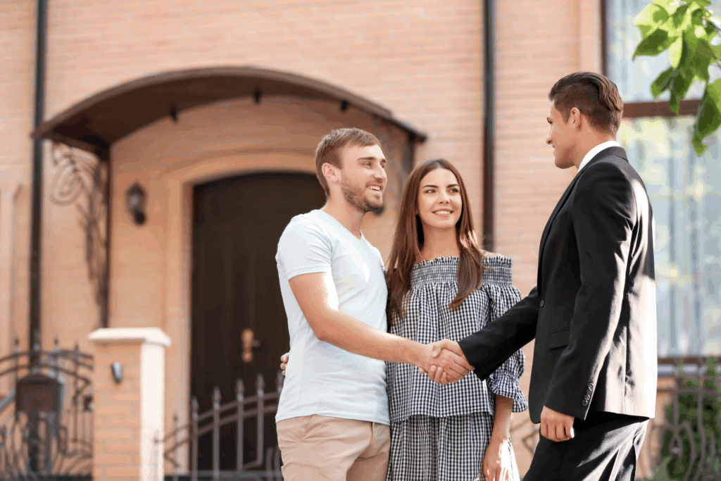 Letting agent shaking hands with a couple outside a home in Worcester, reflecting landlords preparing for May 2026 possession and rent review reforms.