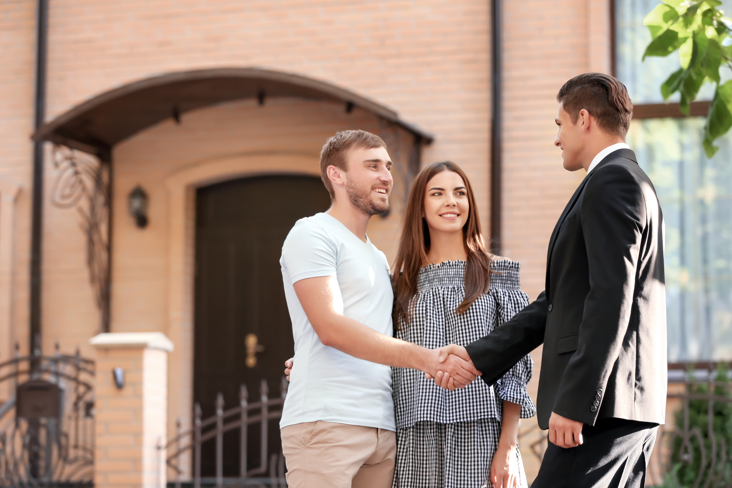 Letting agent shaking hands with a couple outside a home in Worcester, reflecting landlords preparing for May 2026 possession and rent review reforms.