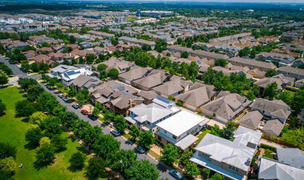 Aerial view of a residential neighbourhood with rows of houses and green streets