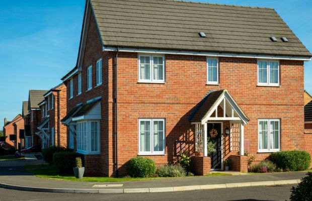 Two-story brick house with windows and landscaping.