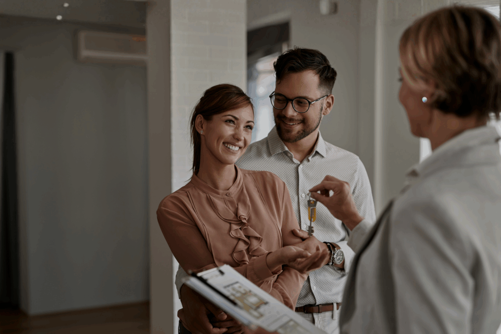Letting agent handing keys to a couple after agreeing a tenancy, reflecting high-yield buy-to-let demand in Widnes WA8 7 and Hough Green in 2026.