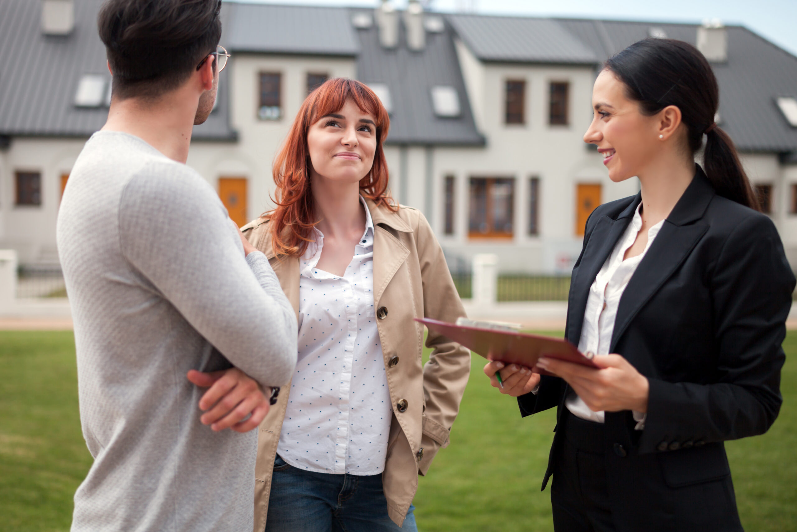 Homeowners speaking with an estate agent outside a modern housing development in Woking during the West Surrey unitary council transition in 2026