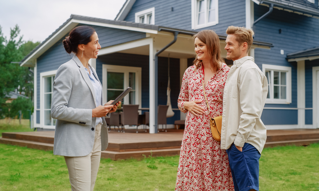 Property agent discussing a home with a couple outside a house, representing estate agents in Paisley and spring property sales