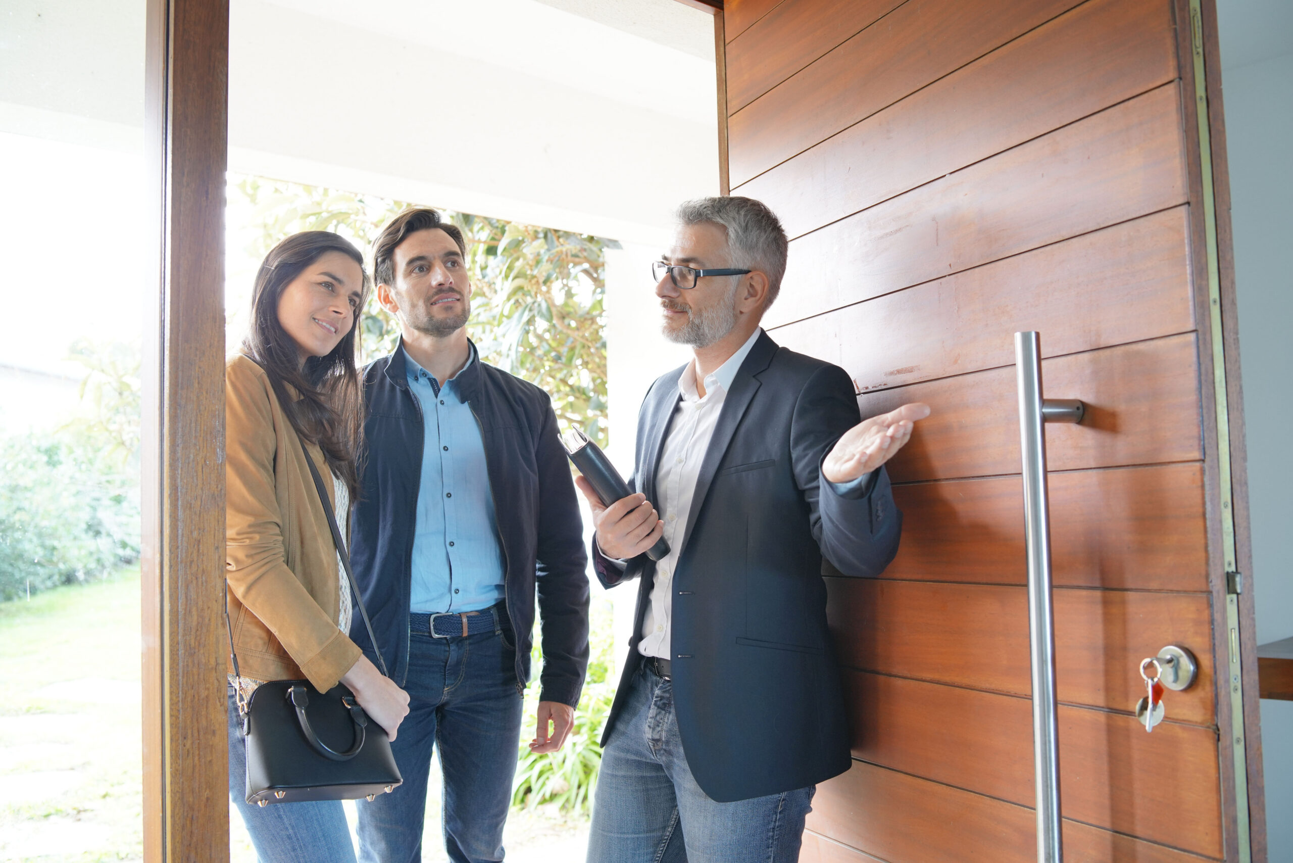 Estate agent discussing tenancy terms with a couple at a property viewing, reflecting new rental compliance rules for landlords in Stoke-on-Trent.