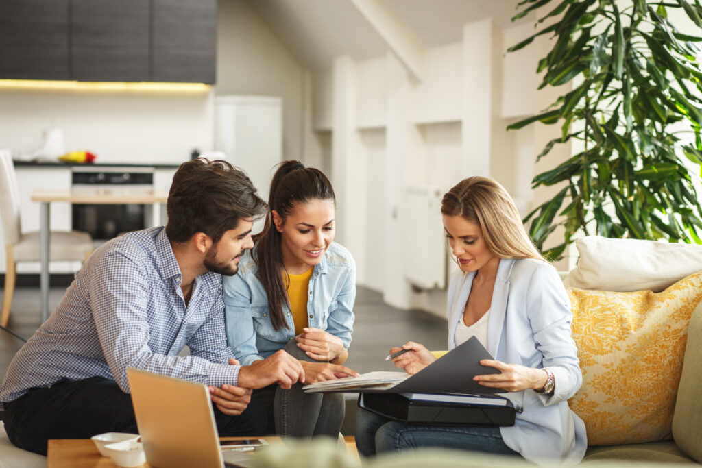 Estate agent discussing property details with a couple during a home consultation in Welwyn Garden City.