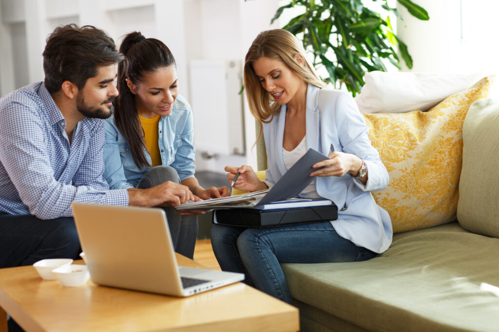 Estate agent reviewing property documents with potential buyers during a home viewing related to selling property in Westbury.