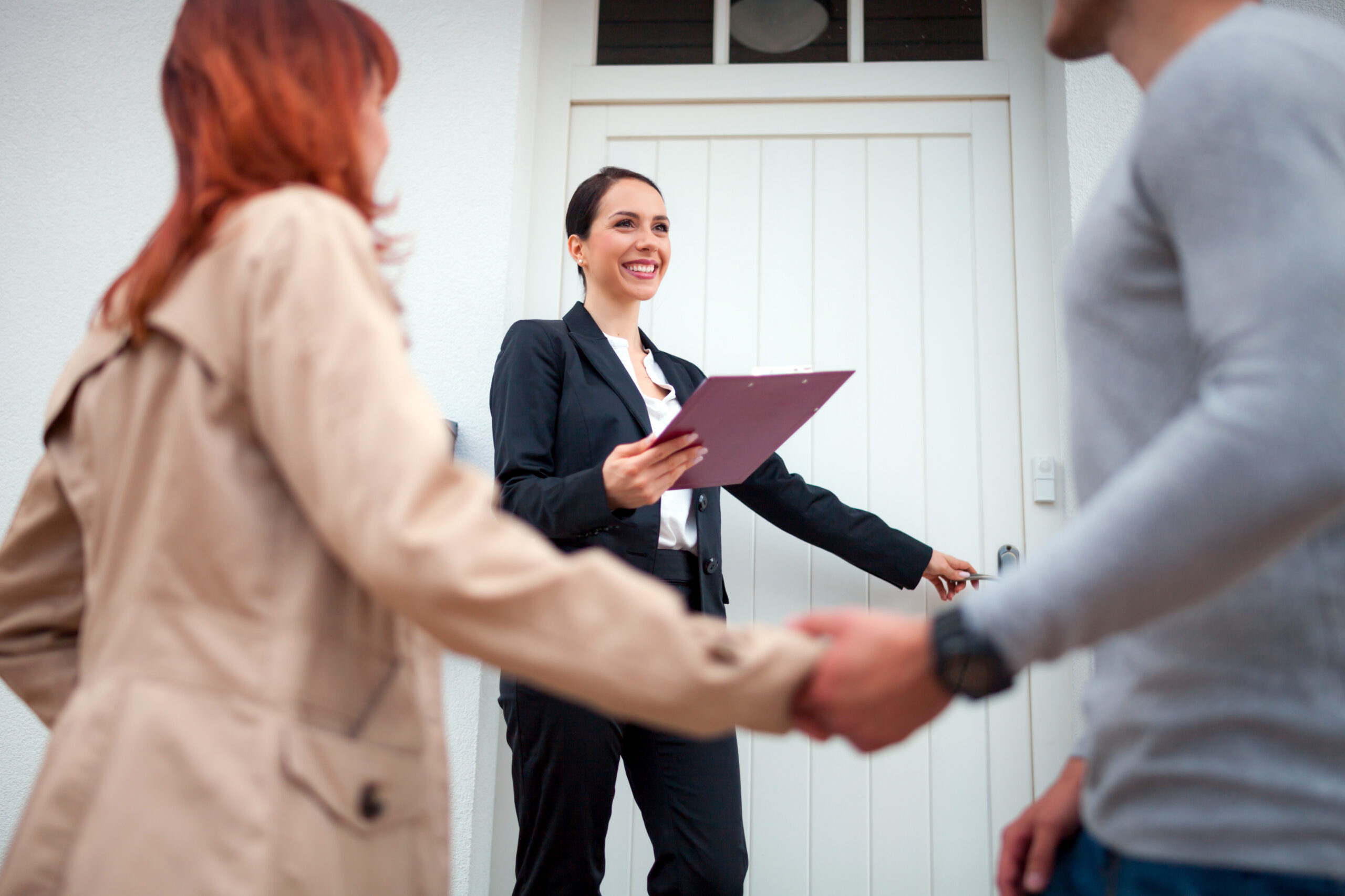 Property manager holding clipboard while greeting tenants at a rental home, representing professional property management in Dunfermline