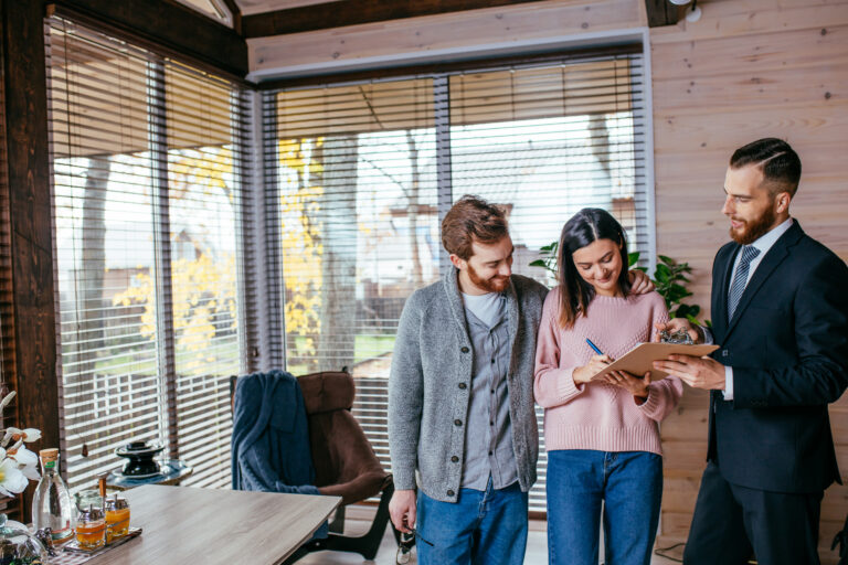 First-time buyers signing property documents with an estate agent inside a modern home in Westbury