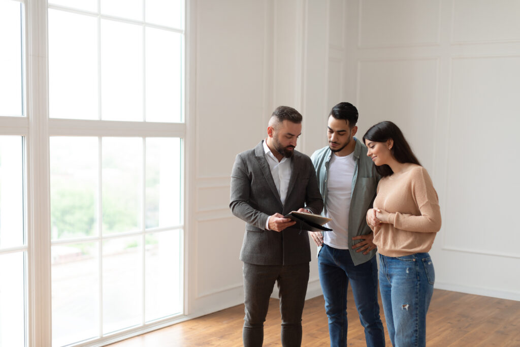 Estate agent showing property details to a couple during a home viewing in Woking