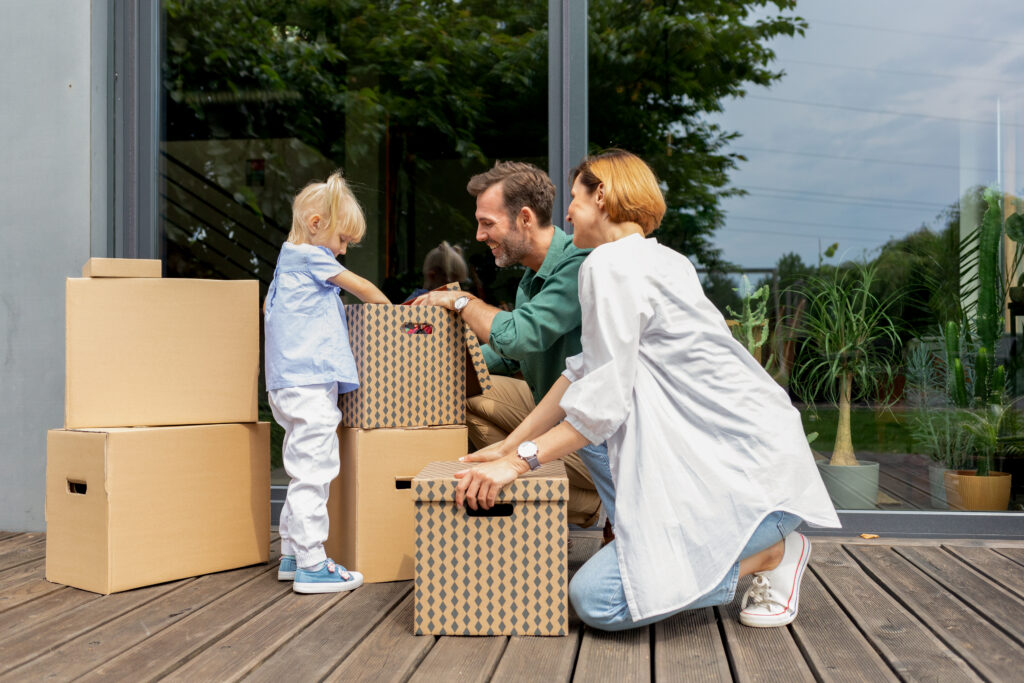 Family with child unpacking moving boxes outside their new home in Knowle or Dorridge