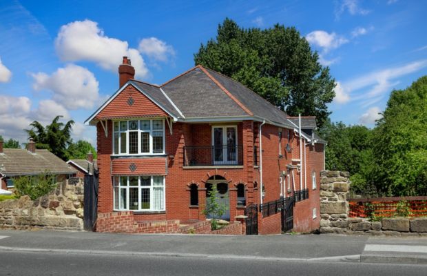 Red brick detached house with bay windows