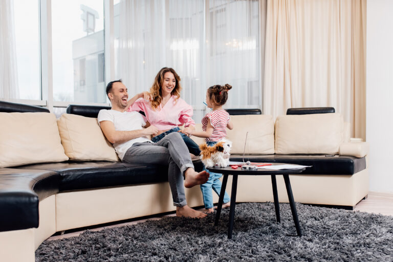 family sitting together on sofa in modern home Solihull West Midlands