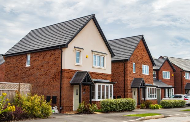 Two modern brick houses with sloped roofs.