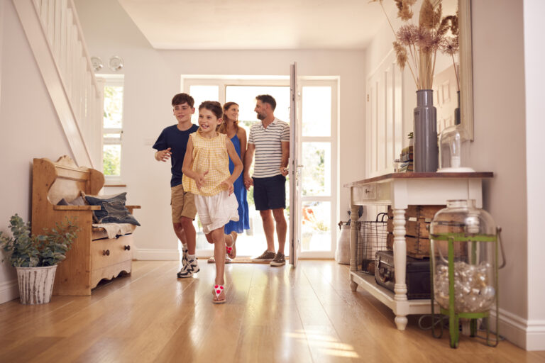 Happy family with children walking into a bright new home for the first time