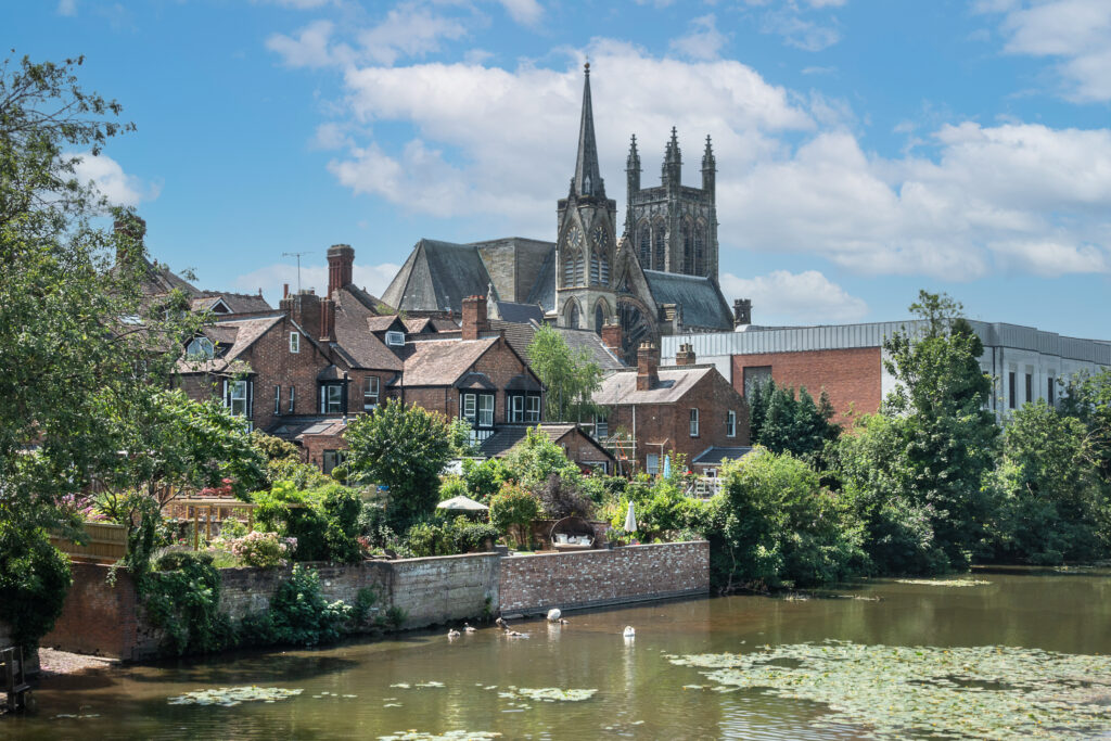 Scenic view of Royal Leamington Spa with residential homes and historic church buildings near the river.