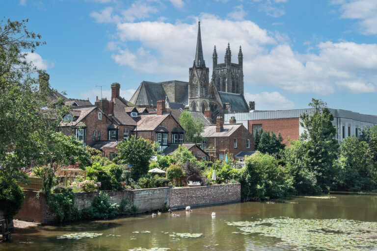 Scenic view of Royal Leamington Spa with residential homes and historic church buildings near the river.