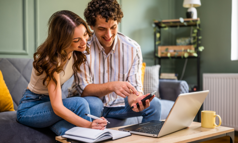 Couple using a laptop and calculator at home, representing Cardiff buyers planning a property purchase under the LTT threshold.