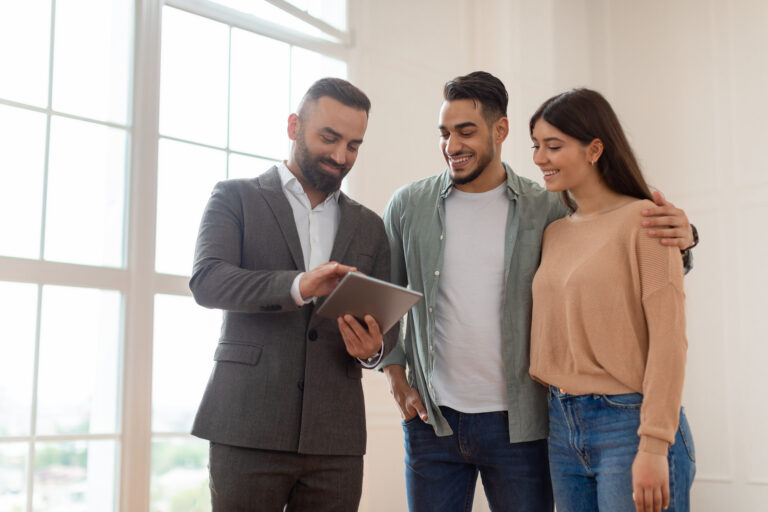 Property agent showing a couple digital rental information, representing Making Tax Digital guidance for Cardiff landlords.
