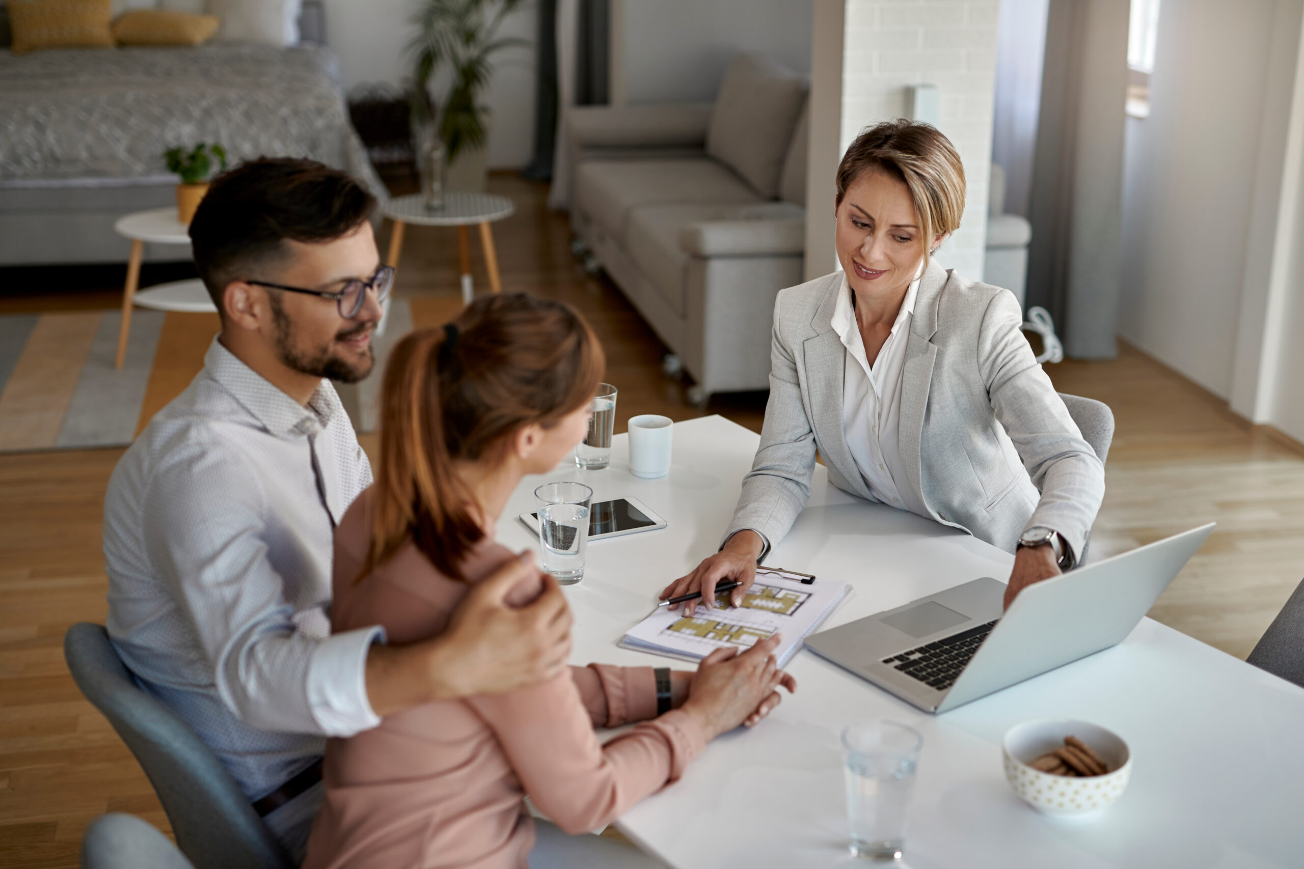 Letting agent advising tenants at a table inside a rental property, representing Chelmsford landlord compliance and property management.