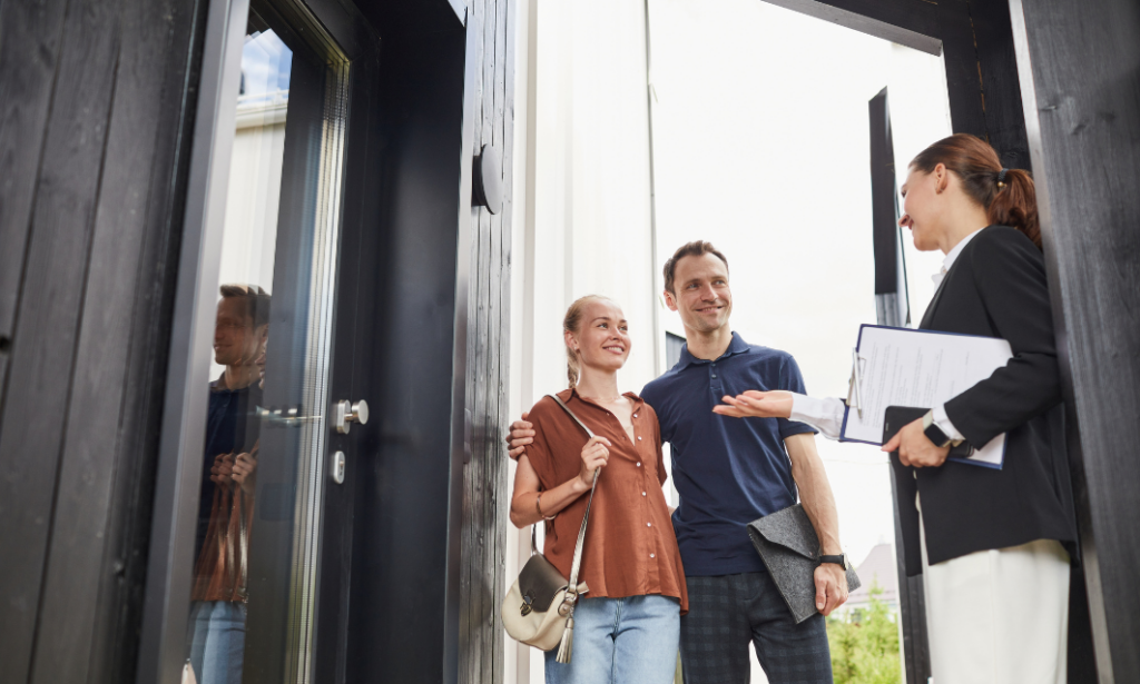 Estate agent greeting a couple at the entrance of a property during a house viewing in Southampton, discussing features and the buying process.