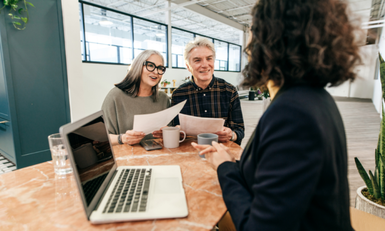 A property consultant speaking with an older couple during a property discussion, representing advice for buyers, sellers, renters and landlords exploring the Hanley ST1 property market.