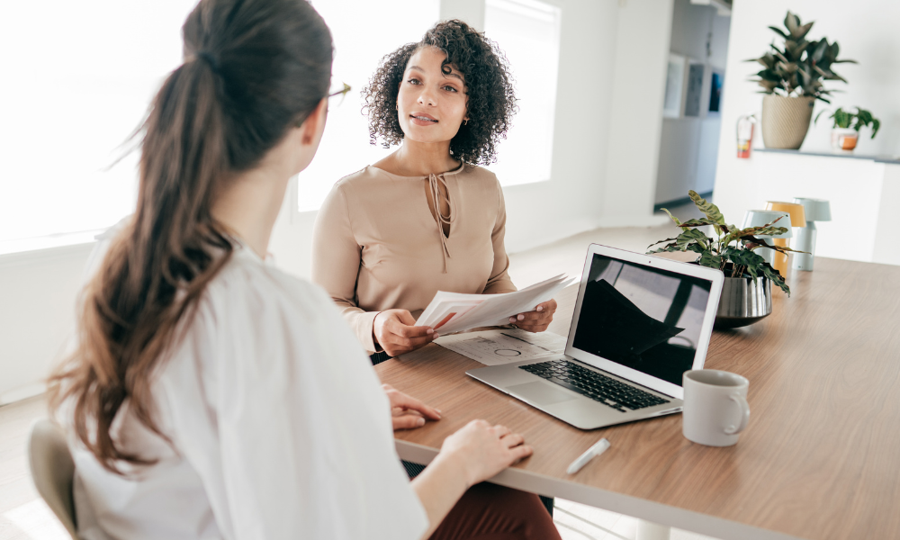 A property consultant discussing documents with a client, representing expert advice for buyers, sellers, renters and landlords exploring the Shirley B90 property market.