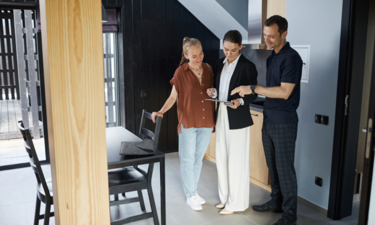 Letting agent showing property details to tenants inside a rental home, representing Mell Square Solihull rents, landlord advice and property management.