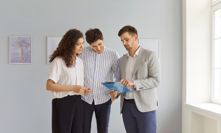 Estate agent showing buyers property details inside a bright home, representing Royal Leamington Spa house prices and buyer demand in 2026.