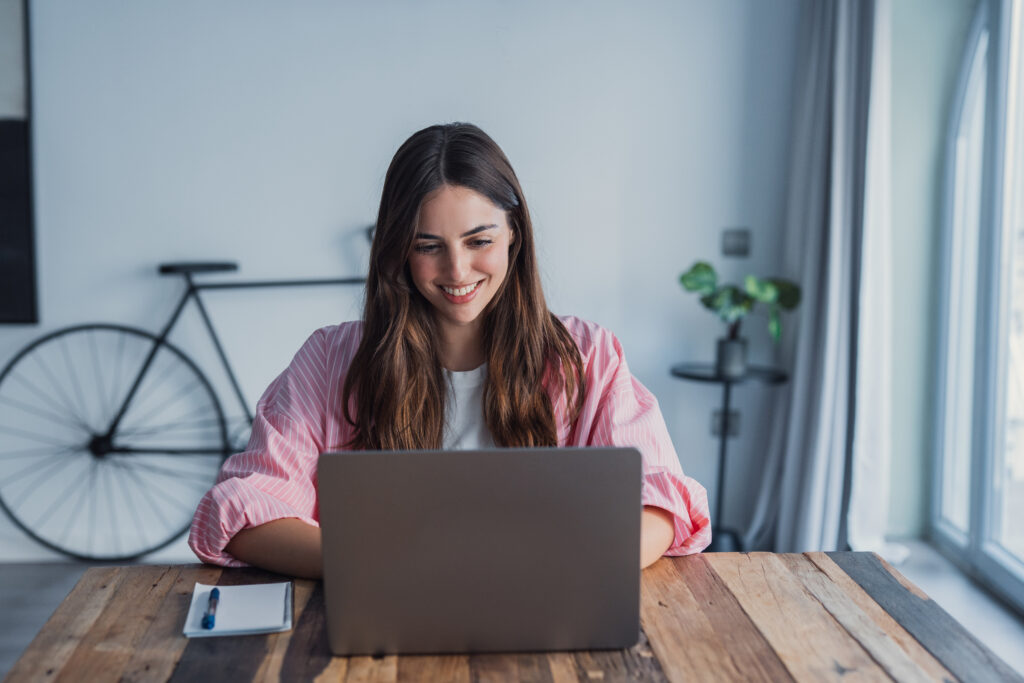 A first-time homebuyer using a laptop to search for properties in Oxford from her living room.