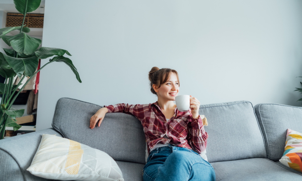 A homeowner relaxing on a sofa in a bright living room, representing confidence and preparation before selling a property in Bath.