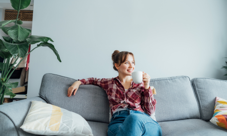 A homeowner relaxing on a sofa in a bright living room, representing confidence and preparation before selling a property in Bath.