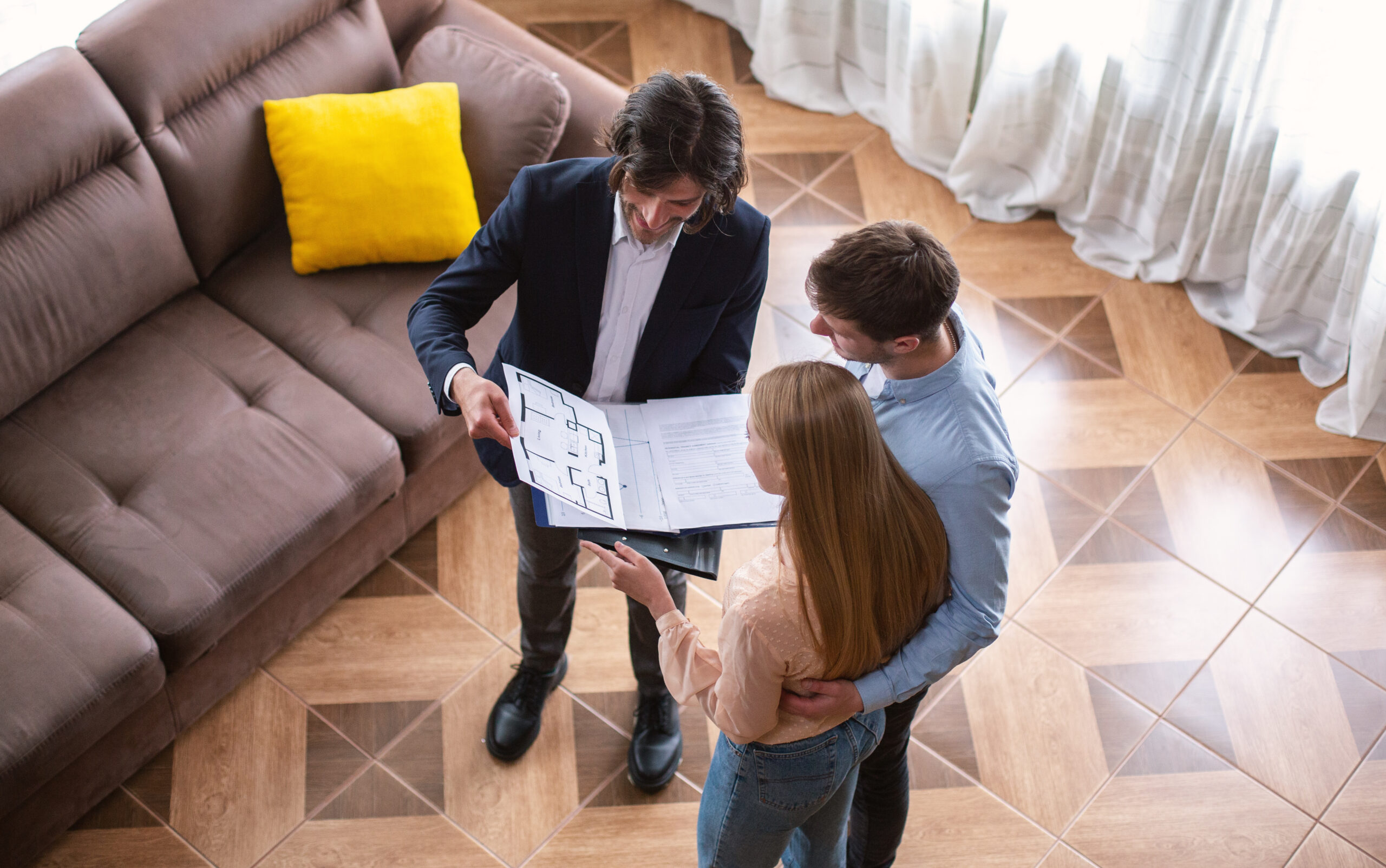 Estate agent showing a couple a property floorplan during a viewing, reflecting tenant management, rental guidance and landlord support in Uckfield.