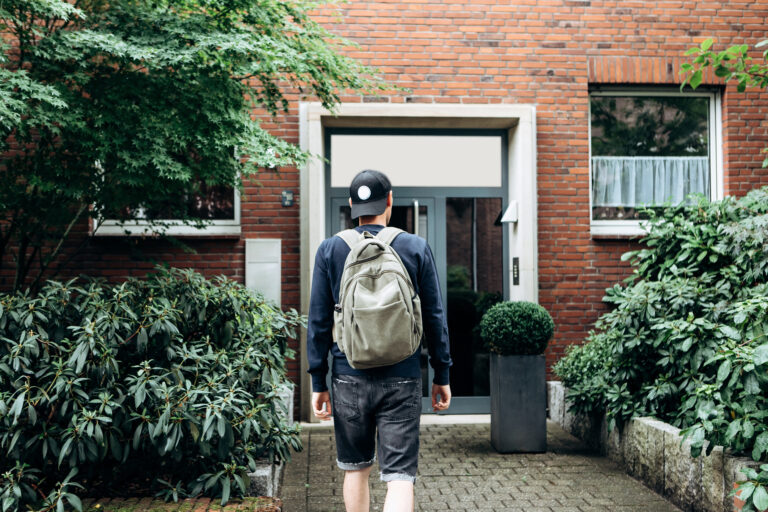 Student walking towards a residential property with a backpack, reflecting student rental demand and landlord opportunities in Bath’s university rental market.