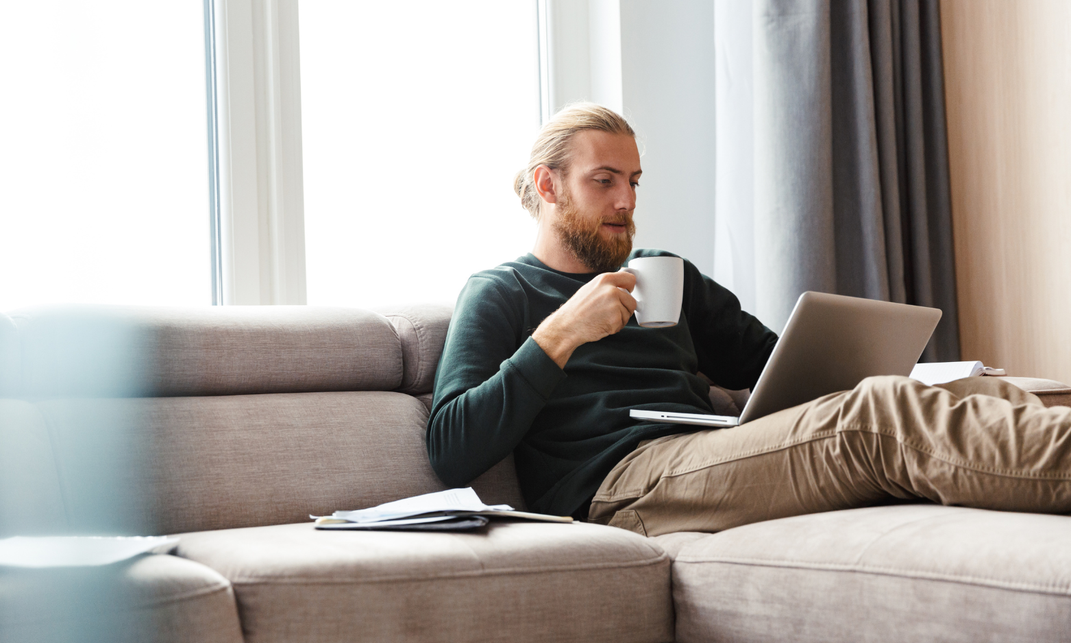 A landlord relaxing at home while reviewing tenancy and property management information on a laptop.