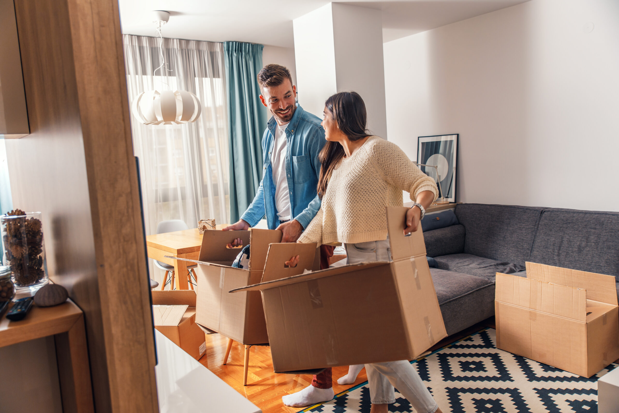 Couple unpacking boxes in their new home, reflecting the excitement of buying a first property in Welwyn Garden City.