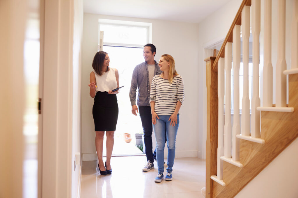 Estate agent showing a couple around a bright home, reflecting property valuation advice and selling guidance for homeowners in Westbury.
